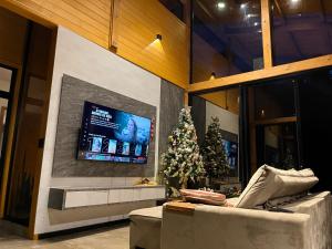 casa de campo rústica para show rural في كاسكافيل: غرفة معيشة مع شجرة عيد الميلاد وتلفزيون