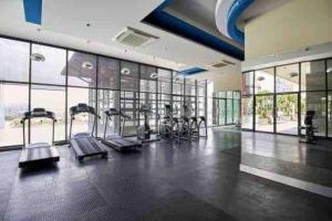 a gym with treadmills and ellipticals in a room with windows at Romantic Couple Bath Tub 6km to KLCC 网红浴缸小红书爆款 in Kuala Lumpur