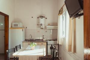 a small kitchen with a table and a refrigerator at Cabañas Madrid in Alta Gracia