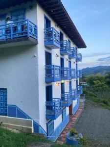 un bâtiment avec des balcons bleus sur son côté dans l'établissement Apartahotel Villa Carolina 2, à Jericó