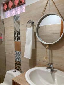 La salle de bains est pourvue d'un lavabo, d'un miroir et de toilettes. dans l'établissement Apartahotel Villa Carolina 2, à Jericó