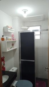 a small bathroom with a black refrigerator and a toilet at Castelo Di Palmas in Campo Grande
