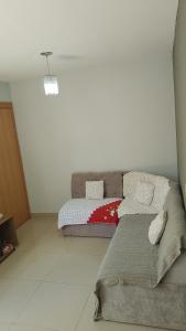 a bedroom with a bed and a couch in it at Castelo Di Palmas in Campo Grande