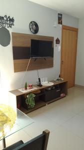 a living room with a flat screen tv on a wall at Castelo Di Palmas in Campo Grande