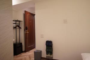 Zimmer mit einer Tür und einem Zimmer mit einer Tasche in der Unterkunft MARUKOU HOTEL in Tokio