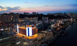 Pohang A1 Hotel Yeongildae Branch في بوهانغ: مدينة مضاءة ليلا مع مبنى كبير