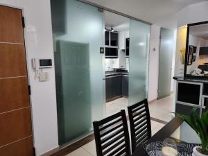 - une salle à manger avec une cloison en verre dans la cuisine dans l'établissement Departamento Alta Gracia, à Alta Gracia