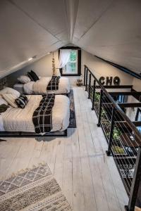 a bedroom with two beds and a staircase at The Fisherman's Cottage - a Lakeside Loft 