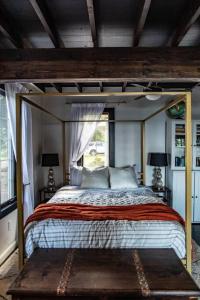 a bedroom with a canopy bed and a window at The Fisherman's Cottage - a Lakeside Loft 