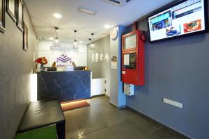 a waiting room with a bar and a tv on the wall at Elite Hotel in Muar