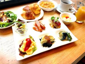 een bord voedsel op een tafel met borden voedsel bij APA Hotel Asakusabashi-Ekikita in Tokyo