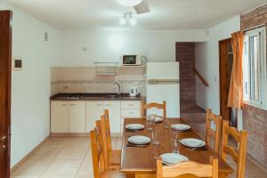 een keuken en eetkamer met een houten tafel en stoelen bij Duplex Madrid in Alta Gracia