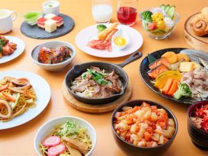 una mesa cubierta con platos de comida y tazones de comida en Hotel WBF Grande Asahikawa en Asahikawa