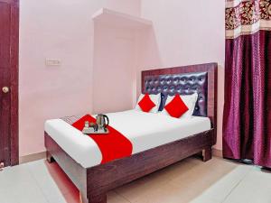 a bedroom with a bed with red pillows at Flagship Rimjhim Garden & Hotel in Patna