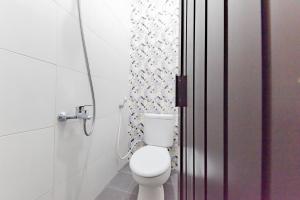 a bathroom with a white toilet in a room at Urbanview Hotel Sunday Cirebon by RedDoorz in Cirebon +13 photos