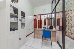 a kitchen with a desk and a blue chair at Urbanview Hotel Sunday Cirebon by RedDoorz in Cirebon
