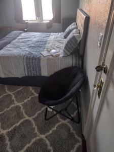 a black chair sitting in a room next to a bed at Clearviewpeace in Paterson