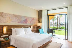 a hotel room with a bed and a balcony at Hoi An Memories Resort & Spa in Hoi An