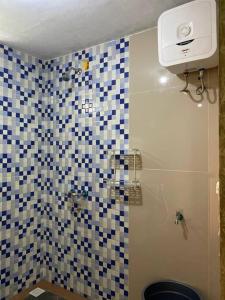 La salle de bains est pourvue d'une douche avec du carrelage bleu et blanc. dans l'établissement Villa Adendri Riverhills, à Megamendung