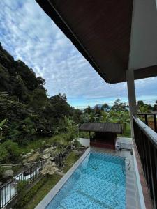 a swimming pool on the balcony of a house at Villa Adendri Riverhills in Megamendung