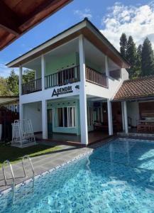 une maison avec une piscine en face d'un bâtiment dans l'établissement Villa Adendri Riverhills, à Megamendung