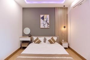 a bedroom with a white bed and a mirror at Every Day Guest House - Phan Thiet in Ấp Bình Hưng