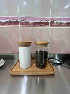 two jars of spices on a cutting board at Bayu Homes(Cozy 4 BedRoom SemiD in KT City Center) in Kuala Terengganu