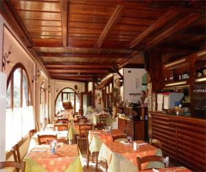 a restaurant with tables and chairs and wooden ceilings at Hotel Bellagio in Ovada