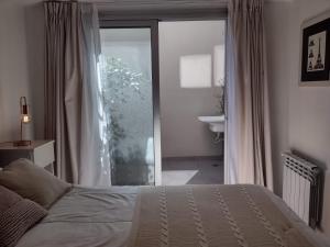 een slaapkamer met een bed en een glazen schuifdeur bij Moderno 2amb con cochera in Mar del Plata