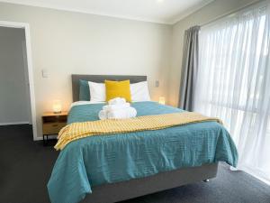 een slaapkamer met een groot bed met een gele en blauwe deken bij Modern and Comfortable Home in Flagstaff in Hamilton