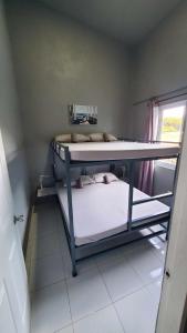 two bunk beds in a small room with a window at Hidden Palms Inn/Resort La Union in San Juan