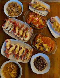 una mesa cubierta con platos de marisco y otros alimentos en BatuRundung Surf Resort en Naibos