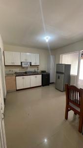 a kitchen with white cabinets and a table and a refrigerator at apartamento entero en santa Gema interior 202 in Medellín