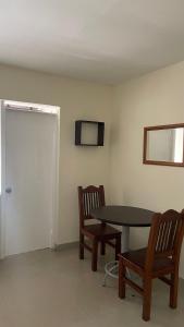 a room with a table and two chairs and a door at apartamento entero en santa Gema interior 202 in Medellín