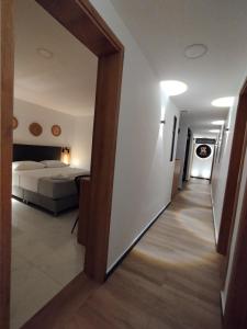 a hallway leading to a bedroom with a bed at Zamá Room Hotel in Medellín