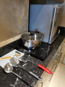 una encimera de cocina con una sartén y utensilios. en Warhol Residence at Louis Kienne Semarang Simpang Lima, en Semarang