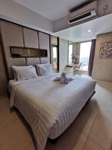 a teddy bear sitting on a bed in a bedroom at Warhol Residence Semarang Simpang Lima in Semarang +56 photos