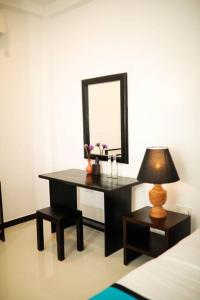 a bedroom with a desk with a mirror and a lamp at Villa Ayu in Galle