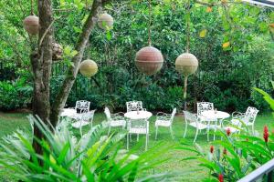 grupa stołów i krzeseł w ogrodzie w obiekcie Villa Ayu w mieście Galle