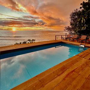 a swimming pool with a view of the ocean at BatuRundung Surf Resort in Naibos