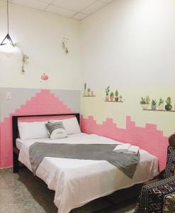 a pink walled bedroom with a large bed at Homestay Vườn nhãn in Pleiku