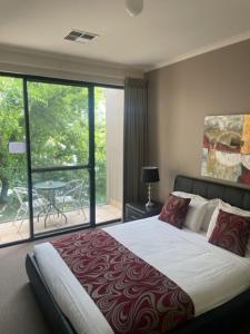 a bedroom with a large bed and a balcony at RNR Sturt Holiday Home in Adelaide
