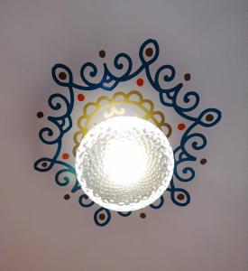 una luz colgada del techo con un diseño en Hostal arbol cafe caicedonia, en Caicedonia