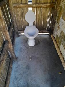 uma casa de banho com WC numa cabina de madeira em Glowing Mountain view tree house em Loanengo