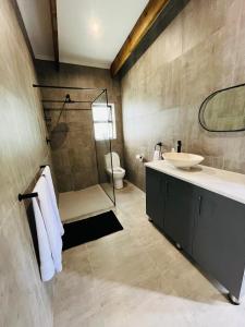 a bathroom with a shower and a sink and a toilet at 21 Heather Road in George