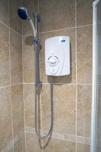 La salle de bains est pourvue d'une douche et d'un distributeur de savon. dans l'établissement Comber Cozy Home, à Comber