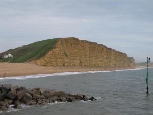 a beach with a large rock pile in the water at Hudsons Guest House - Adults only in Weymouth