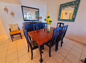 a dining room table and chairs with a vase of flowers on it at Ripple In Time- Gorgeous Views- Tennis- BBQ in Umdloti