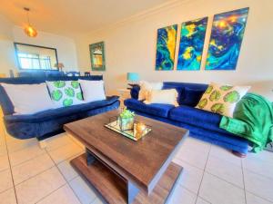 a living room with blue couches and a coffee table at Ripple In Time- Gorgeous Views- Tennis- BBQ in Umdloti +49 photos