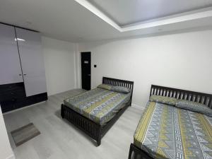1 Schlafzimmer mit 2 Betten und einem Spiegel in der Unterkunft Cozy Haven in Manila